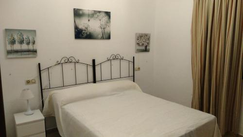 阿尔加尔Alojamiento rural " Las Carmenes "的一间卧室配有一张带白色床罩的床