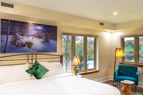 亨茨维尔Fairy Bay Lakehouse的一间卧室配有一张床、一张蓝色椅子和窗户。