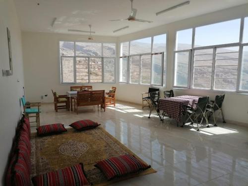 MisfāhMisfah View的客厅配有桌椅和窗户。