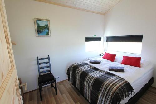 雷克霍特Blue View Cabin 1A With private hot tub的一间卧室配有一张带红色枕头的床和一把椅子
