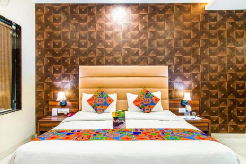 博帕尔FabHotel Prime President- Near to Bhopal Airport的一间卧室设有一张大床和一面墙