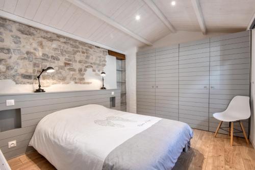 雷岛圣玛丽MACÉDOCY Maison de charme au cœur du Village的卧室配有白色的床和白色椅子
