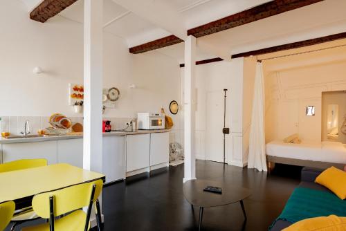马赛Mini Loft au coeur du Panier - Marseille的厨房以及带桌子和床的客厅。