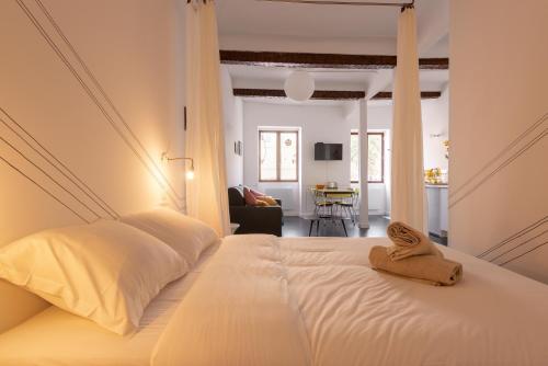 马赛Mini Loft au coeur du Panier - Marseille的卧室配有白色的床和毛巾