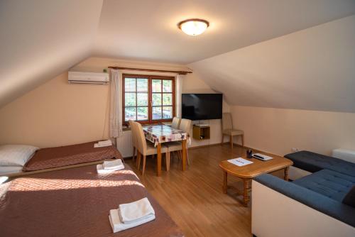 米库洛夫Apartmán a ubytování U Machů的客房设有两张床、一张沙发和一张桌子。