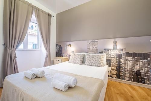丰沙尔Cayres Suites Carmo的卧室配有带毛巾的大型白色床