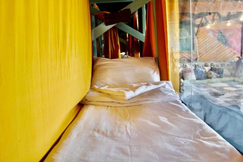 NimrodNomad Hostel的黄色墙的房间里一张床位