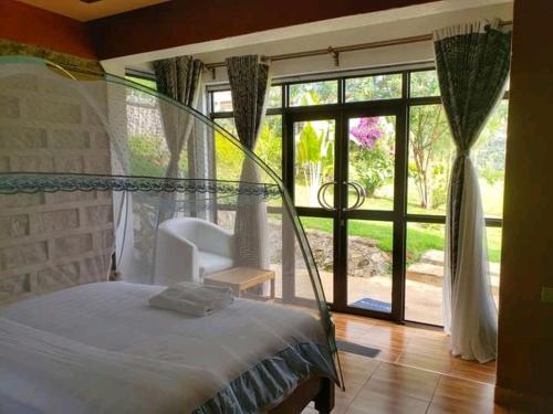 MbaleSipi Valley Resort的一间卧室设有一张床和一个大窗户