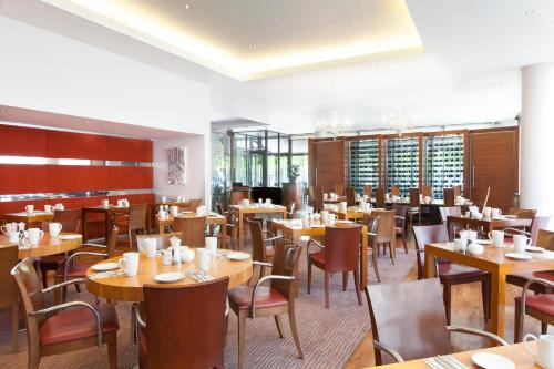 伦敦皇冠假日伦敦多克兰酒店的用餐室配有木桌和椅子