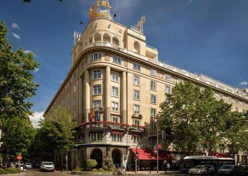 马德里Wellington Hotel & Spa Madrid的一座大型建筑,上面有一座塔