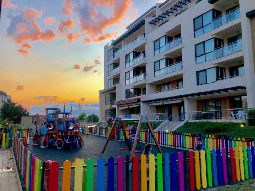 奥布佐尔Obzor Beach Resort的建筑物前带游乐场的五颜六色的围栏