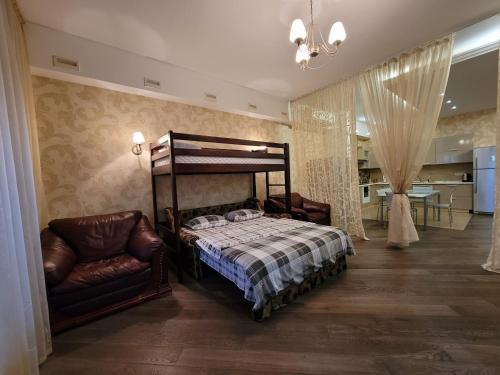 敖德萨阿卡迪亚公寓的一间卧室配有一张床和一把椅子