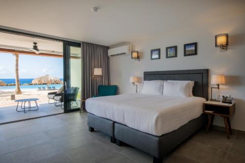 威廉斯塔德库拉索阿维拉海滨酒店的一间卧室配有一张床,享有海滩美景