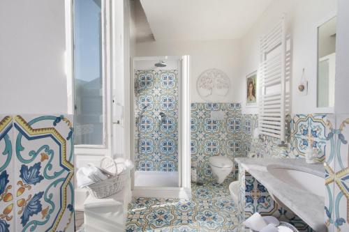皮雅诺迪索伦托Caluga House的浴室铺有蓝色和白色的瓷砖,配有浴缸。