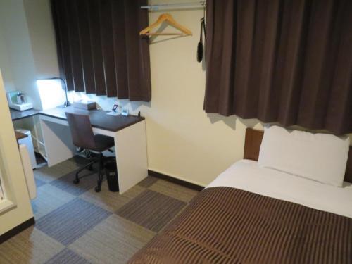 釜石Hotel Marue - Vacation STAY 78769v的酒店客房配有一张床和一张带电脑的书桌