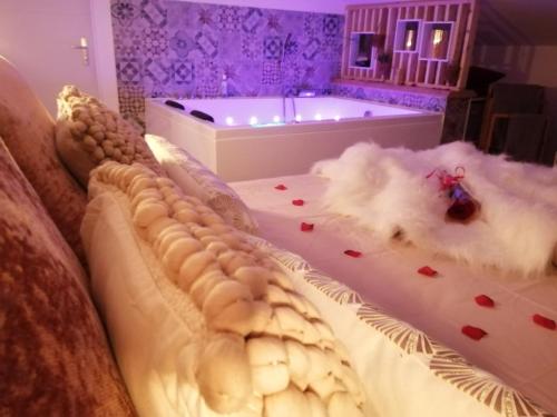 Pont-de-VeyleEscapade Veyloise-Nuit romantique-Spa-Champagne的一间带浴缸的卧室和一张鲜花床