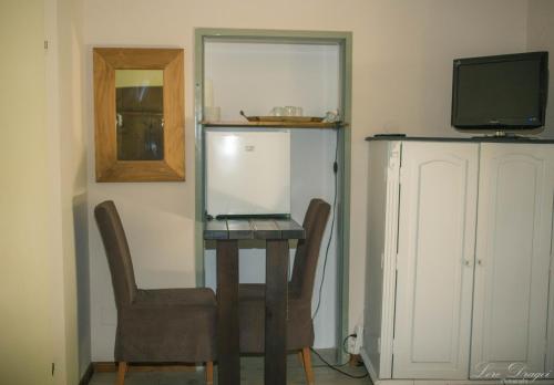 PăulişPensiunea Dulce Ambient的配有桌子和两把椅子以及电视的房间