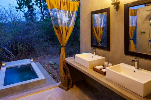 雅拉Makini Bush Camp, Yala的浴室配有两个盥洗盆和浴缸。