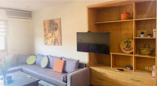 马拉喀什Gueliz YSL的带沙发和平面电视的客厅