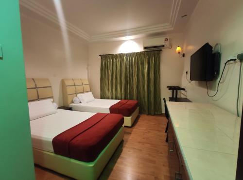 克提DARUL SALAM INN HOTEL的酒店客房设有两张床和一台平面电视。