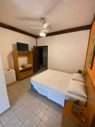 巴拉尤娜Pousada Samburá的卧室配有一张白色大床和电视。