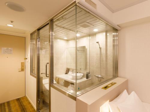 高山Chisun Grand Takayama的一间带玻璃淋浴和水槽的浴室