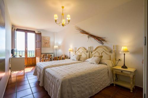 新阿森西奥Mar de viñas的一间卧室配有两张床和吊灯。