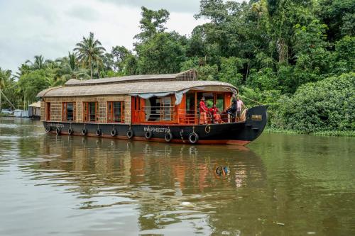 库玛拉孔Grand Villa Houseboat的一条船上的人在河上