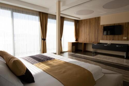 艾瓦勒克Carpe Diem Hotel的一间卧室配有一张大床和电视