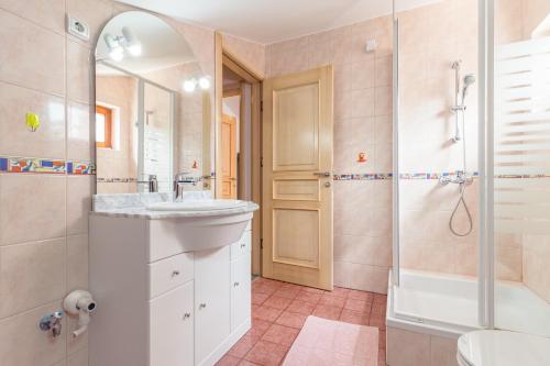 布耶Villa Nada的浴室配有水槽、淋浴和浴缸。