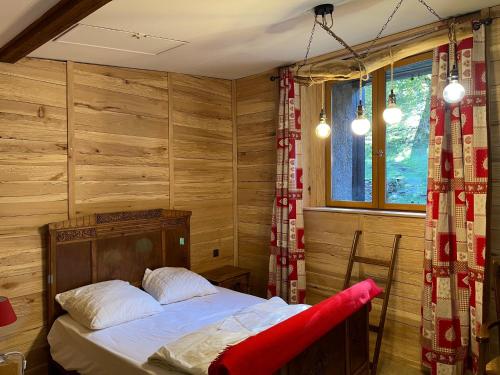AuzatGrange rénovée, Pyrénées Ariégeoises, Gîte haute Ariège的卧室配有一张床铺,位于带木墙的房间内