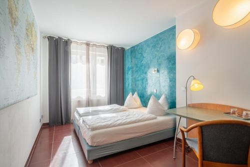 美因茨Hotel Schottenhof的配有一张床和一张书桌的酒店客房