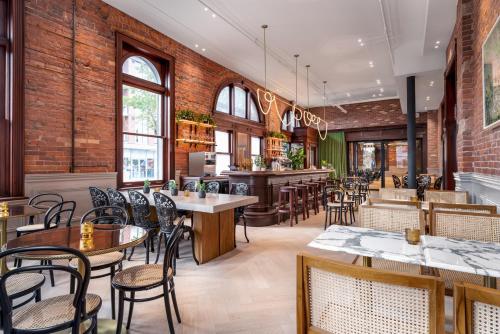 多伦多Gladstone House的一间带桌椅的餐厅和一间酒吧