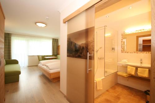 斯拉德明诺维尔特阿尔盆酒店的带淋浴的浴室和1间带1张床的卧室