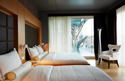 阿姆斯特丹阿马迪公园酒店的一间卧室设有两张床和大窗户