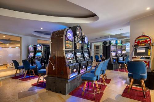 蒙特哥贝伊贝罗斯塔大玫瑰堂度假村的赌场设有数台老虎机和蓝色椅子