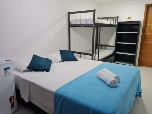 阿布拉奥Suites Golfo的一间卧室配有一张带蓝色毯子的床铺和双层床。