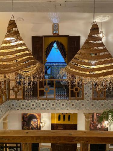 拉巴特RIAD Dar Ouezzani的带壁炉的客房内设有2个大吊灯