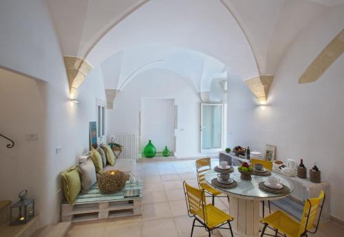 莱切Corte dei Romiti Apartment的客厅配有桌子和黄色椅子