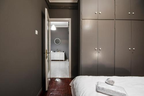 塞萨洛尼基Thessaloniki Center Apartment的卧室配有白色的床和镜子
