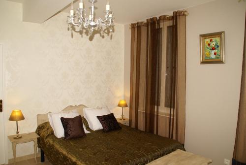 拉蒙维尔圣阿尼克洛斯托罗伞旅馆的一间卧室配有一张床和一个吊灯