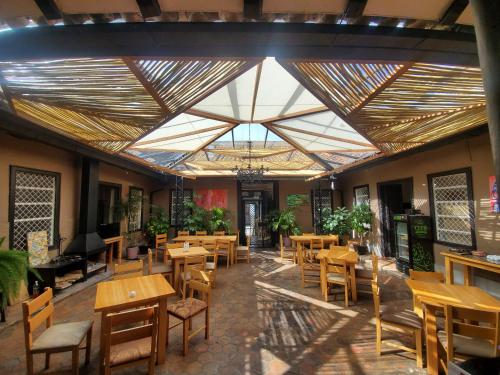 昆卡Hotel Casa Merced的餐厅设有木桌和椅子以及大型天花板。
