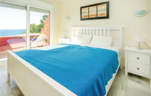 Estepona2 Bedroom Cozy Apartment In Estepona的一间卧室配有一张带蓝色毯子的床和窗户。
