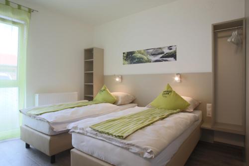 坎普河畔加尔斯智能汽车旅馆的两张带绿色枕头的床