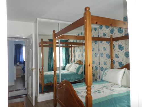 洛斯托夫特日出度假屋的一间卧室配有一张四柱床。