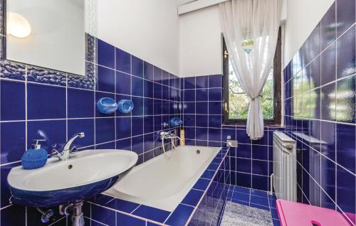 里耶卡Beautiful Apartment In Rijeka With House A Panoramic View的蓝色瓷砖浴室设有水槽和浴缸