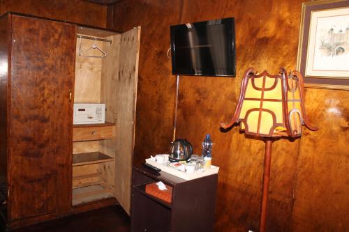 内罗毕奥克伍德酒店 的木墙上配有电视的房间