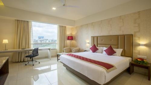 达文盖雷Sai International Hotel的酒店客房设有一张大床和一张书桌。