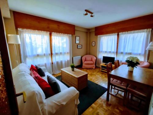 塞尔塞迪利亚Apartamento Puerto de Navacerrada的客厅配有白色的沙发和桌子