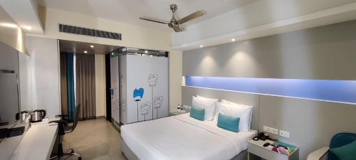 海得拉巴ZIBE Hyderabad by GRT Hotels的一间卧室配有一张蓝色条纹的白色床